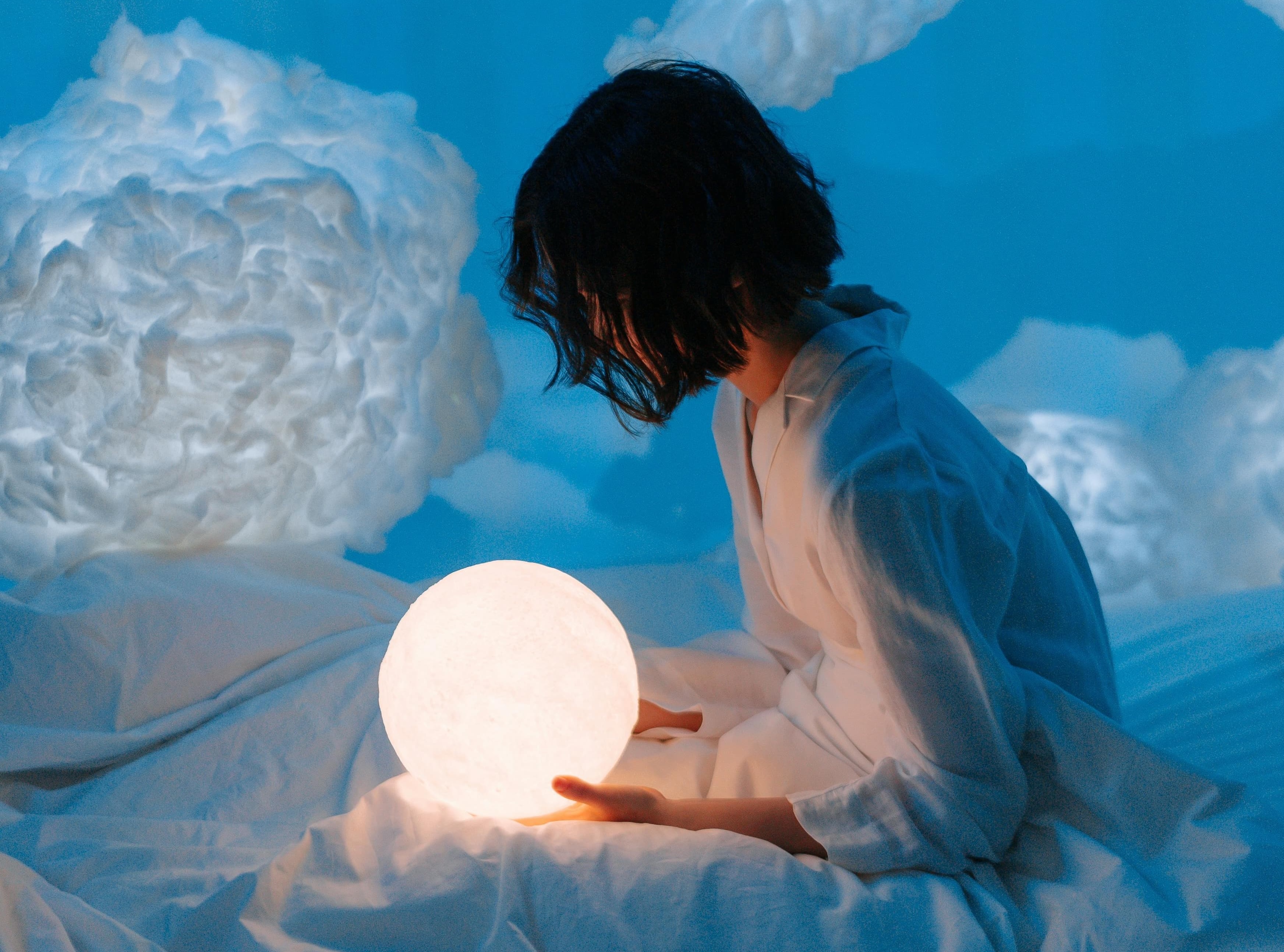 жінка в блакитній кімнаті, наповненій хмарами